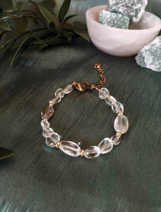 Goldenes Bergkristall Perlenarmband mit weißen Natursteinen liegend auf grünem Tuch, Ansicht von oben