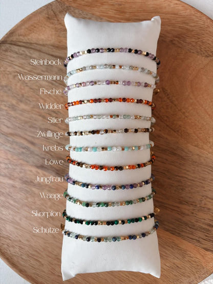Sternzeichen Armbänder mit bunten Edelstein Perlen aufgereiht auf Schmuckkissen