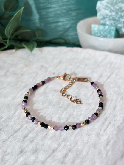 Goldenes Edelstein Armband mit Amethyst und Onyx Perlen liegend auf weißem Tablett, Detailansicht
