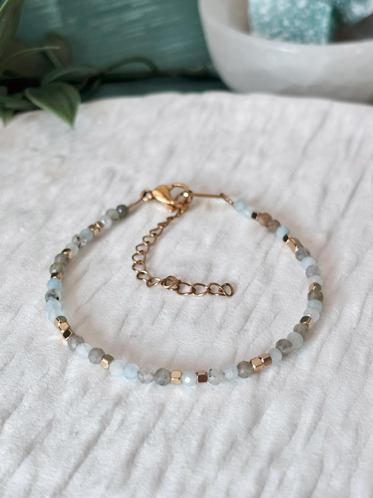 Goldenes Edelstein Armband mit Labradorit und Aquamarin Perlen liegend auf weißem Tablett, Detailansicht