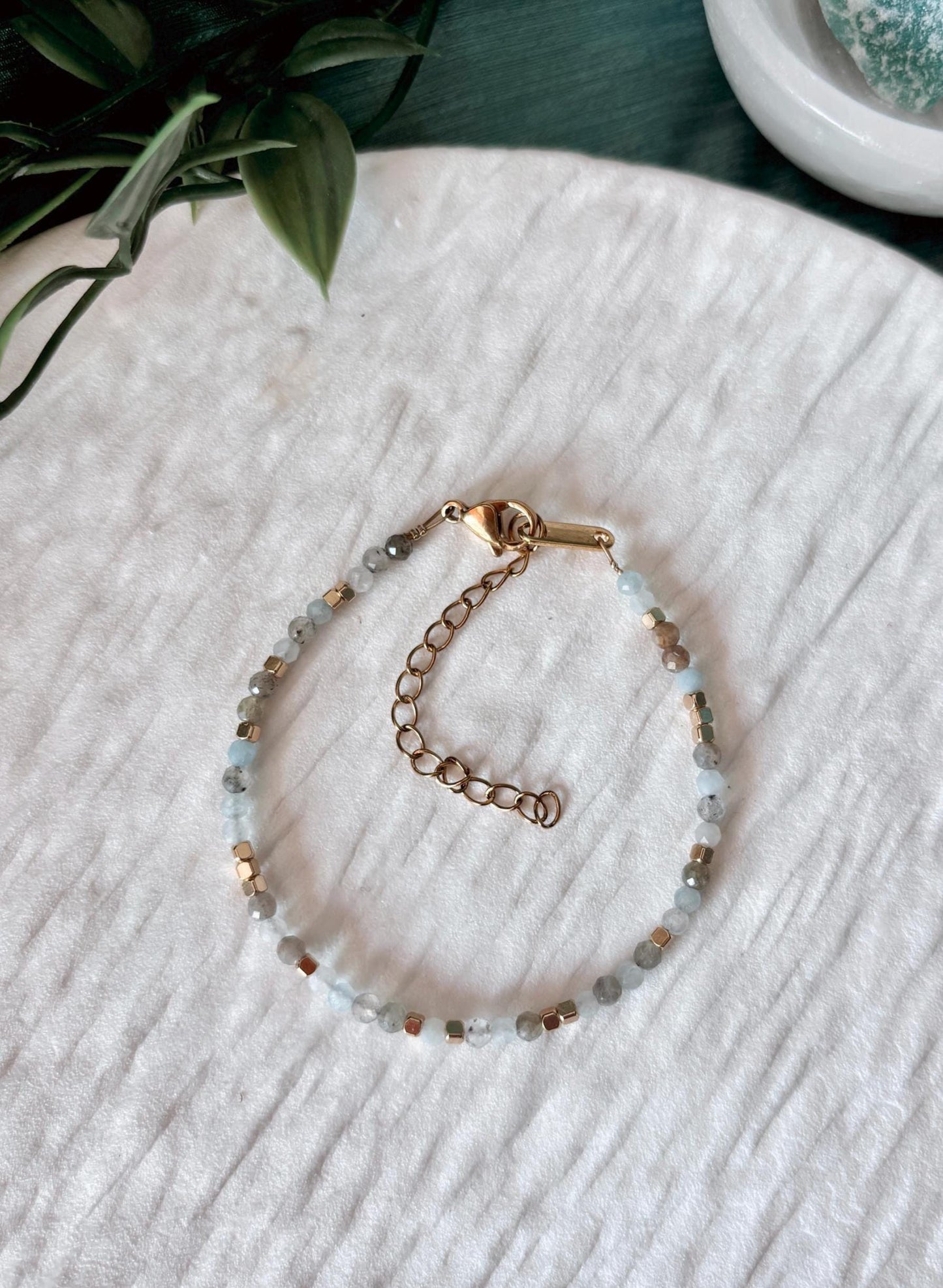 Goldenes Edelstein Armband mit Labradorit und Aquamarin Perlen liegend auf weißem Tablett, Ansicht von oben