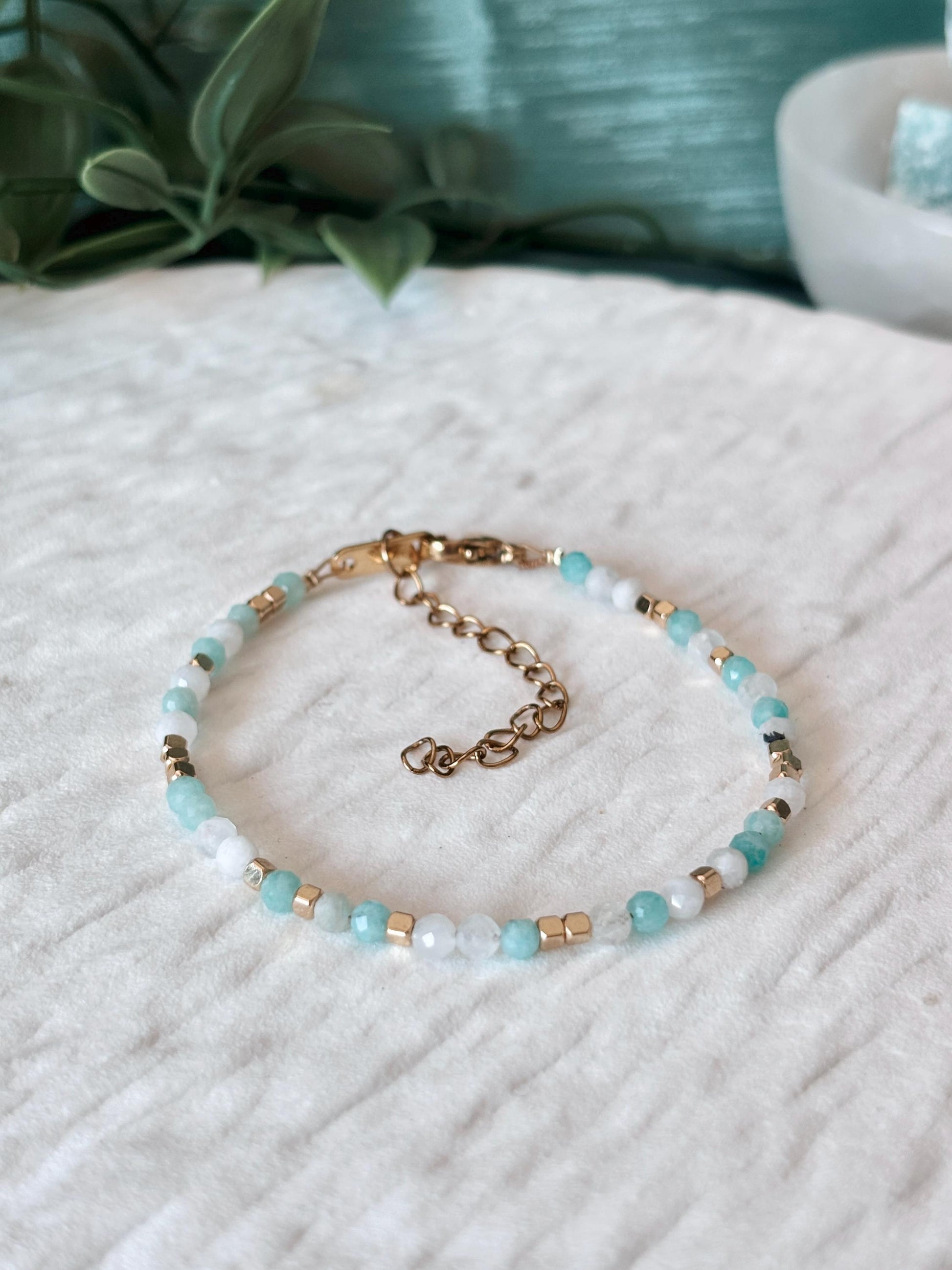 Goldenes Edelstein Armband mit Mondstein und Amazonit Perlen liegend auf weißem Tablett, Detailansicht
