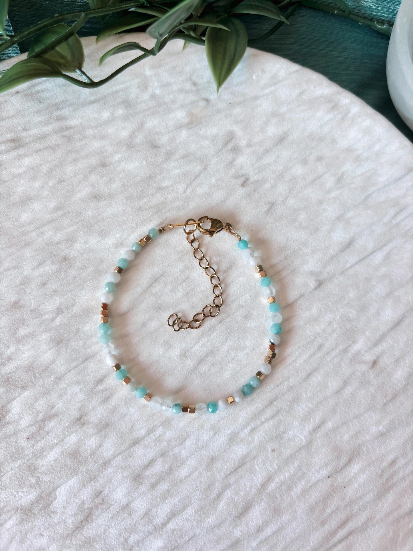 Goldenes Edelstein Armband mit Mondstein und Amazonit Perlen liegend auf weißem Tablett, Ansicht von oben