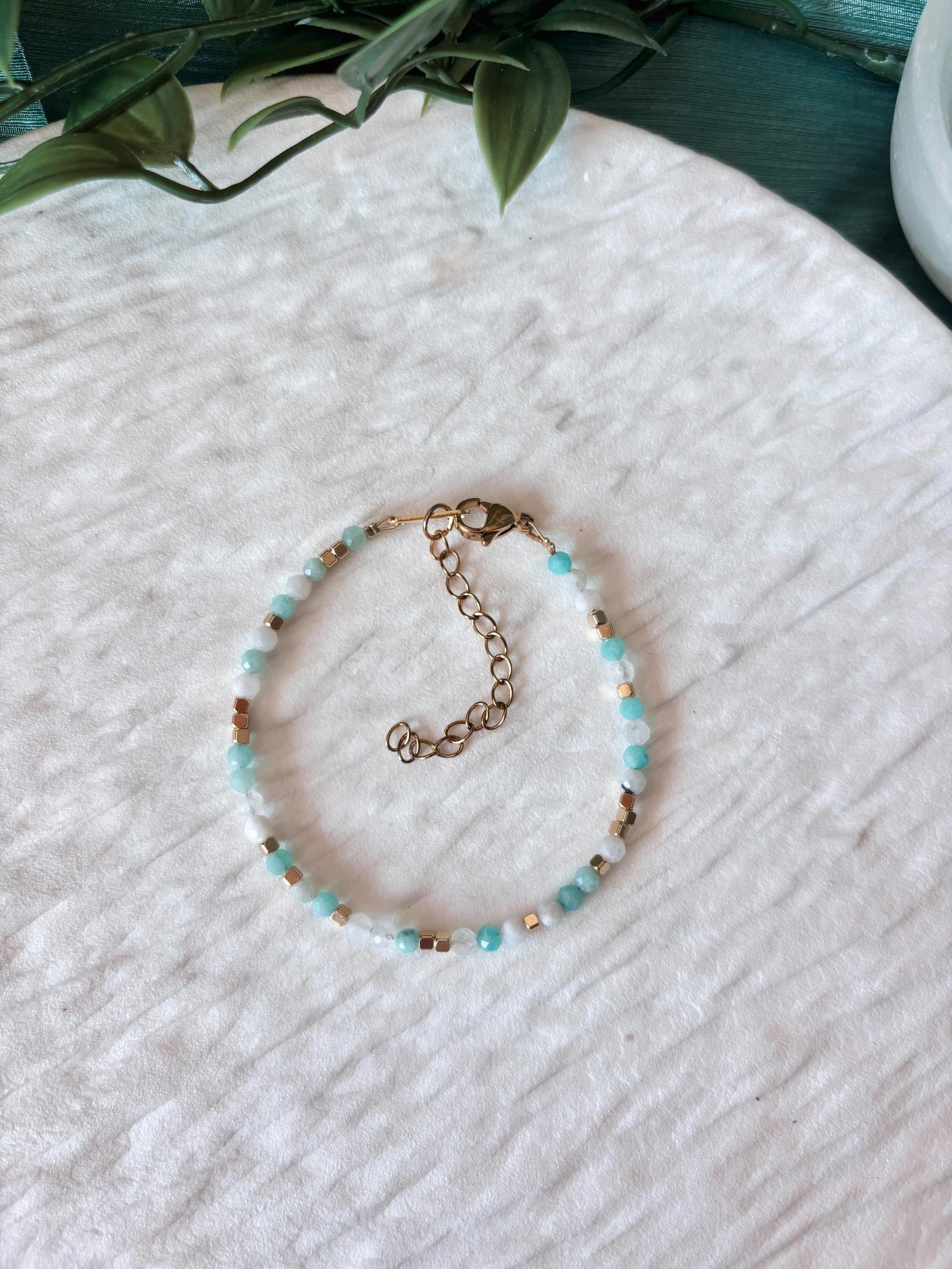 Goldenes Edelstein Armband mit Mondstein und Amazonit Perlen liegend auf weißem Tablett, Ansicht von oben