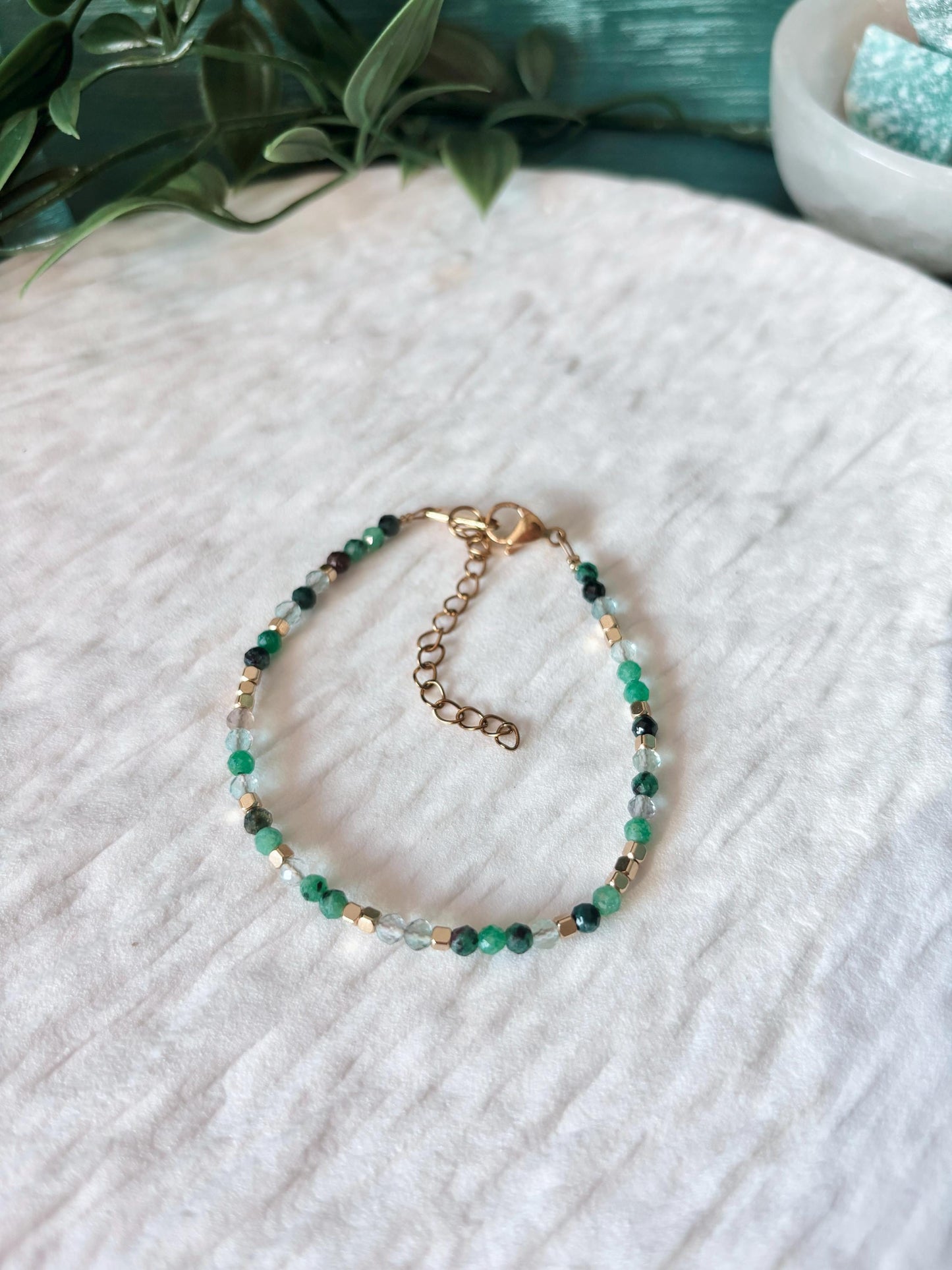 Goldenes Edelstein Armband mit Smaragd und Aventurin Perlen liegend auf weißem Tablett, Ansicht von oben