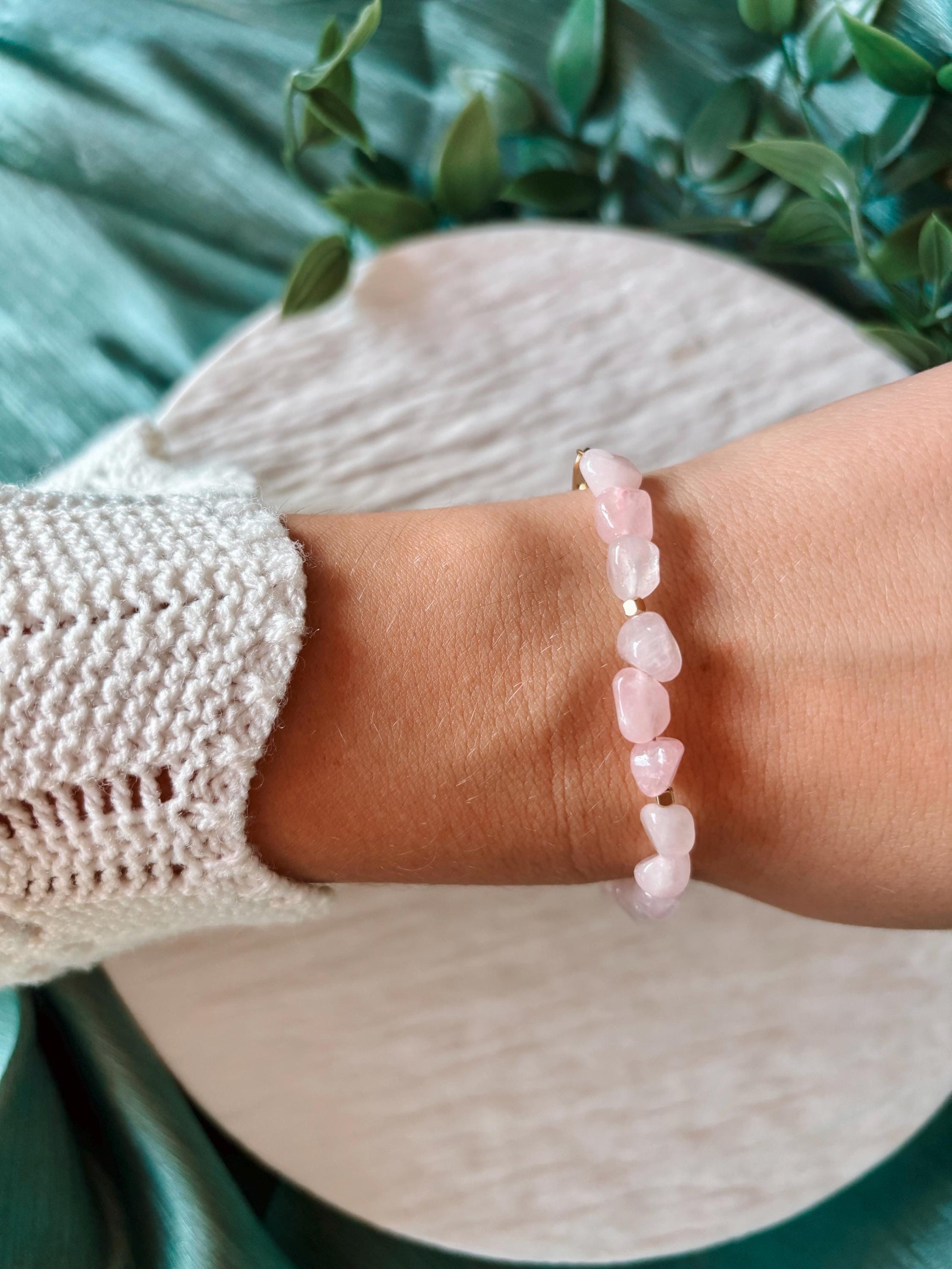 Goldenes Rosenquarz Perlenarmband mit rosa Natursteinen am Handgelenk