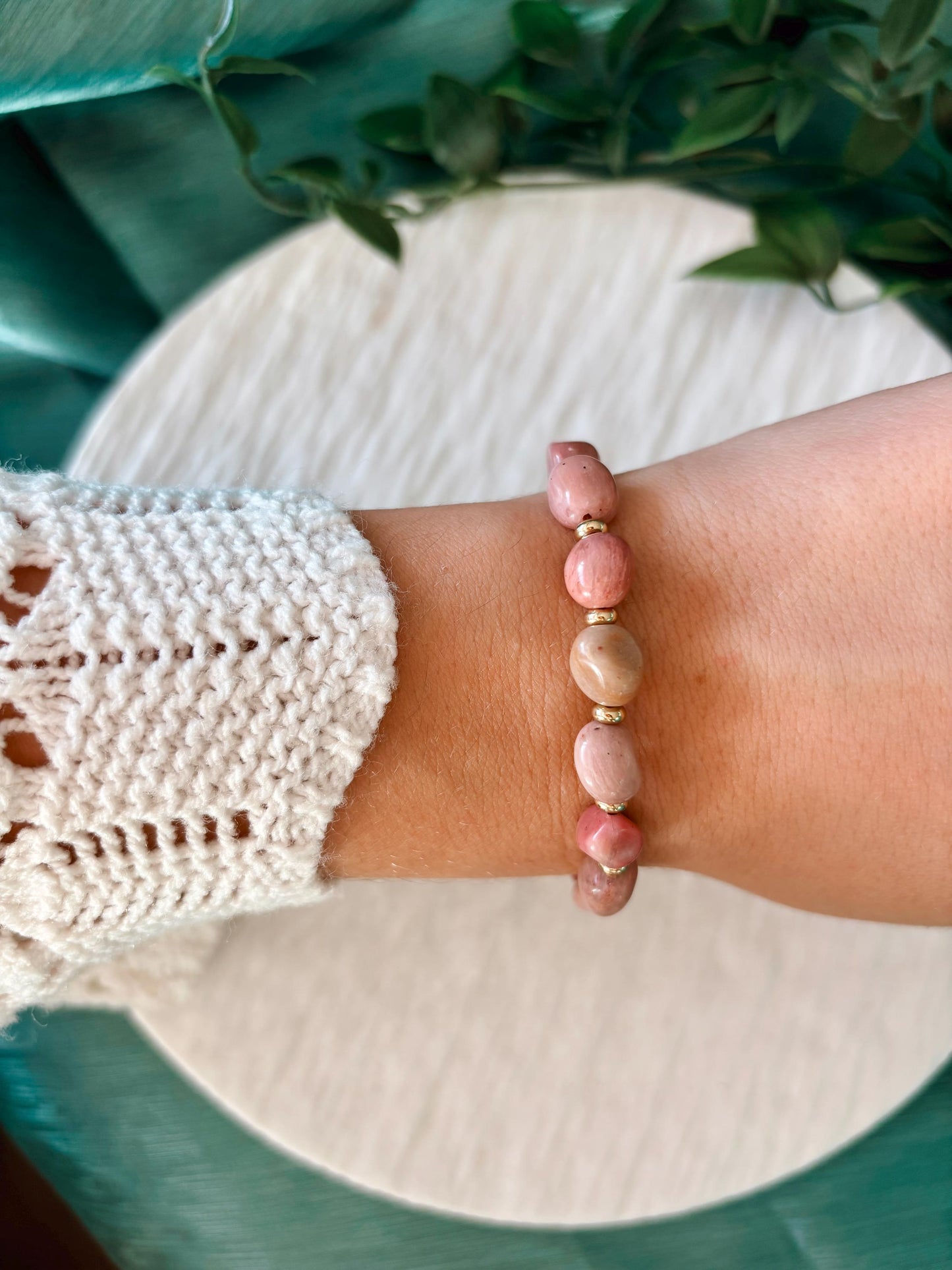 Goldenes Rhodonit Perlenarmband mit rosa Natursteinen am Handgelenk