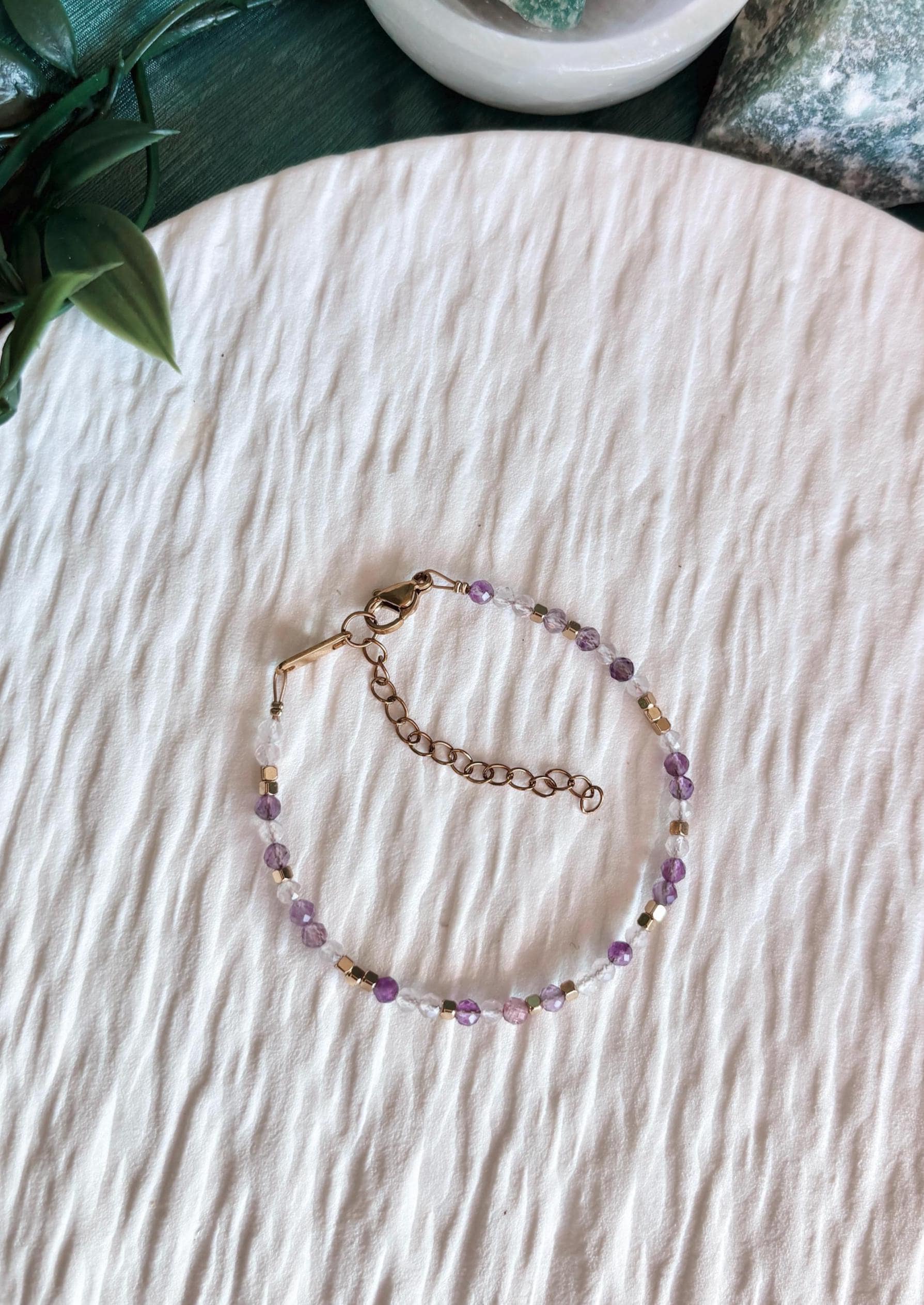 Goldenes Edelstein Armband mit Rosenquarz und Amethyst Perlen liegend auf weißem Tablett, Ansicht von oben