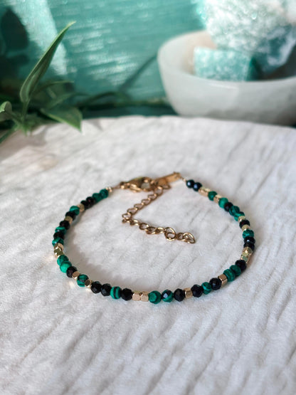 Goldenes Edelstein Armband mit Onyx und Malachit Perlen liegend auf weißem Tablett, Detailansicht